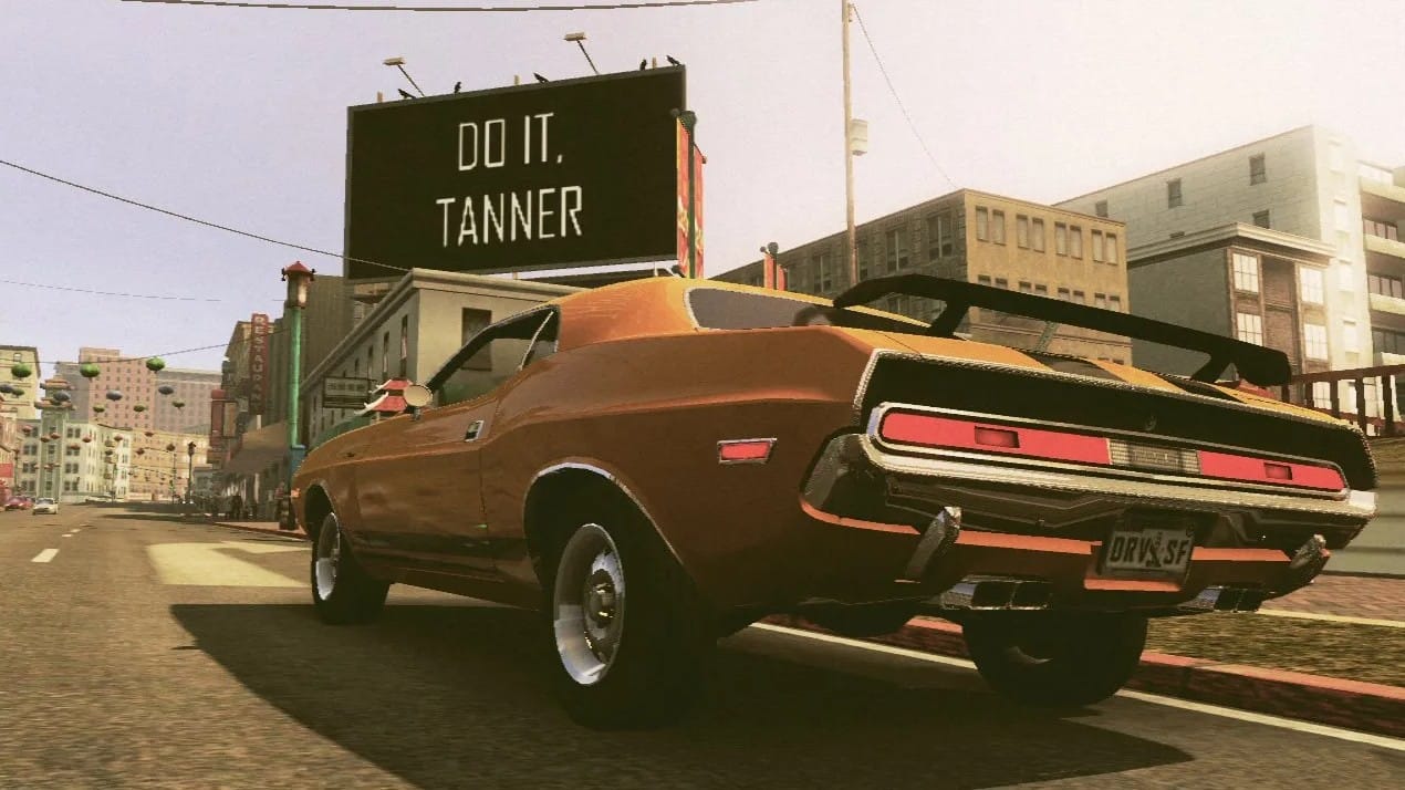 A screenshot from Driver San Francisco with Tanner's car parked as he reads a billboard that says "Do It, Tanner."