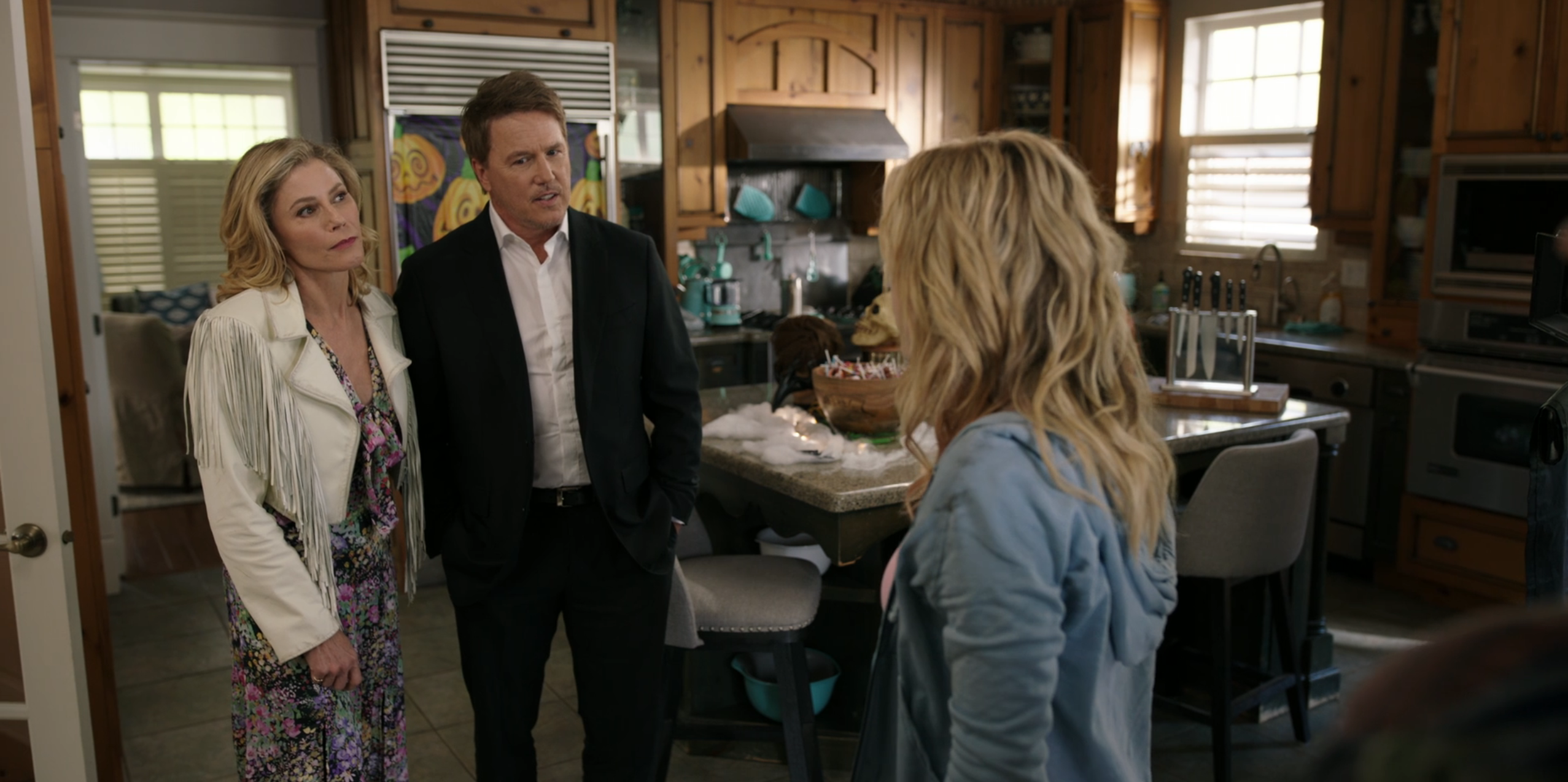 A still from Totally Killer (2023) showing main character Jaime standing in the kitchen with her parents.